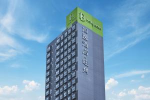 a tall building with a sign on top of it at Hotel Ease Mong Kok in Hong Kong