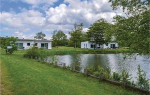 a couple of white houses next to a lake at Nice Home In Ringkbing With 2 Bedrooms And Wifi in Hee
