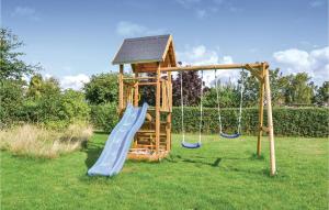 un parque infantil de madera con tobogán y columpios en Awesome Home In Skibby With Kitchen, en Brønde