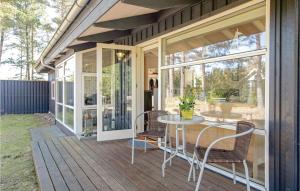 a screened in porch with a table and chairs at Holiday Home Odde Naturpark Vi in Helberskov +15 photos