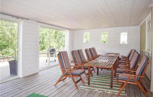 a porch with a wooden table and four chairs at Lovely Home In Tranås With Kitchen in Bjärsjö
