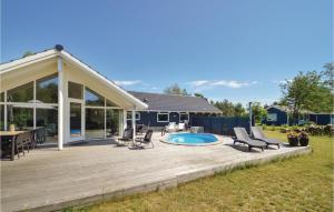 una terraza de madera con sillas y una piscina en Nice Home In Rdby With Wifi, en Kramnitse