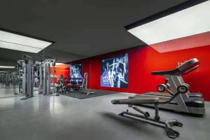 una palestra con parete rossa e macchinari per il cardio-fitness di Wanda Yi, Xi'an The Linow a Xi'an
