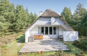 a small white house with a thatched roof at Awesome Home In Rm With Kitchen in Bolilmark