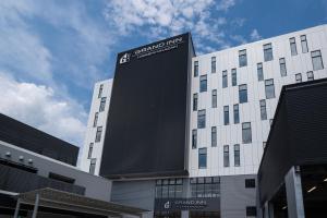 Un edificio con un cartel al costado. en Grand Inn Higashi-Okazaki, en Okazaki