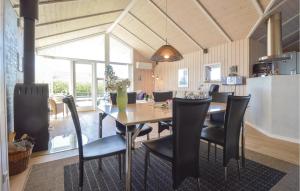 uma sala de jantar com uma mesa de madeira e cadeiras pretas em Nice Home In Tarm With 3 Bedrooms, Sauna And Wifi em Hemmet