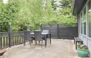 a patio with a table and chairs and a fence at Two-Bedroom Holiday Home Nibe With A Fireplace 06 in Farstrup +15 photos