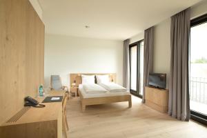a hotel room with a bed and a desk and a television at Hotel Kloster Haydau in Morschen +27 photos