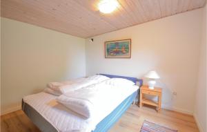 a bedroom with a white bed with a wooden ceiling at Stunning Home In Hurup Thy With House A Panoramic View in Doverodde