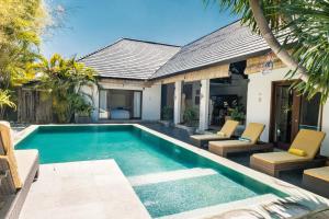 ein Swimmingpool mit Stühlen und ein Haus in der Unterkunft Seminyak Villa in Seminyak