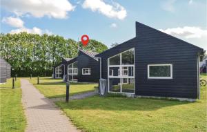 a black house sitting on top of a grass field at Holiday Home Halvejen Hytte Spjald Xii in Spjald