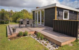 a wooden deck with a table on a tiny house at Two-Bedroom Holiday Home In Knebel in Knebel