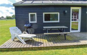 a blue house with a picnic table and a bench on a deck at Holiday Home Halvejen Hytte Spjald Xii in Spjald