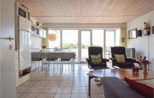 a kitchen and living room with a table and chairs at Terrassehus in Fæbæk