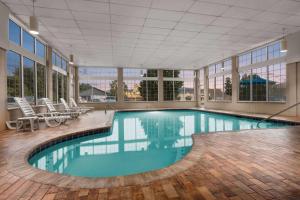 a large swimming pool with chairs in a building at Ramada by Wyndham Pigeon Forge North in Pigeon Forge