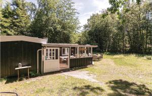 ein kleines Gebäude mit einer Veranda im Hof in der Unterkunft Borkjehuzed in Rønne