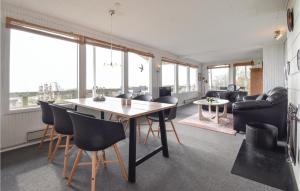 uma sala de estar com mesa e cadeiras em Fyrrehuset em Helnæs By