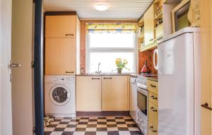 a kitchen with a white refrigerator and a checkered floor at Holiday Home Lodbergsvej Ringkøbing Iii in Søndervig