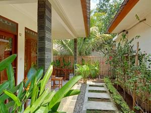 a garden with plants and a patio at Two Brothers Villa in Gili Air