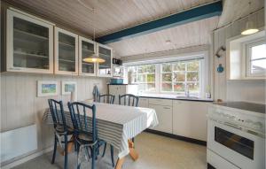 a kitchen with a table and chairs in a kitchen at Holiday Home Lakolk Rømø Denm in Bolilmark