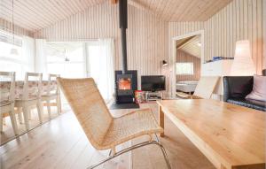 sala de estar con mesa y chimenea en Cozy Home In Ebeltoft With Sauna en Femmøller