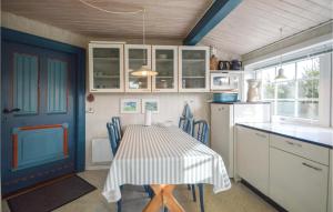 a kitchen with a table with chairs and a blue door at Holiday Home Lakolk Rømø Denm in Bolilmark +9 photos