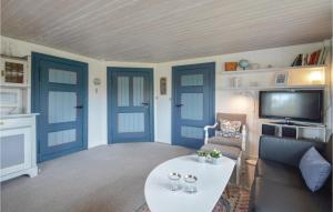 a living room with blue doors and a tv at Holiday Home Lakolk Rømø Denm in Bolilmark