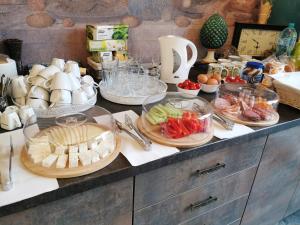 a counter with many plates of food on it at Da Vinci Residence in Sibiu