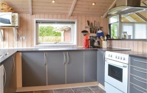 a kitchen with gray cabinets and a window at Awesome Home In Hovborg With Sauna in Hovborg