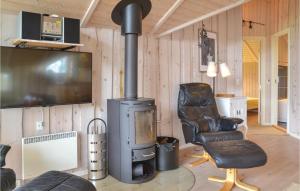 a living room with a wood stove and a chair at Awesome Home In Hovborg With Sauna in Hovborg