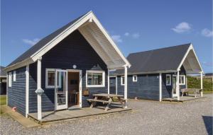 a blue house with a picnic table in front of it at Hytte 22 in Thyborøn +19 photos
