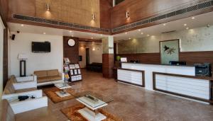 a large lobby with a waiting room with a counter at Pearl Hotel & Banquets Ahmedabad in Ahmedabad