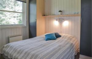 a bedroom with a bed with a blue pillow on it at Holiday Home Fyrrekrogen Vi in Lønne Hede