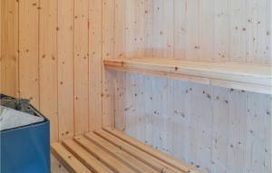 a wooden sauna with a wooden shelf and a trash can at Holiday Home Fyrrekrogen Vi in Lønne Hede
