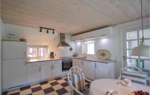 Una cocina con gabinetes blancos y piso a cuadros. en One-Bedroom Holiday Home Rømø With Sea View 01, en Bolilmark