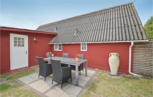 Un patio con una mesa y sillas frente a un edificio rojo. en One-Bedroom Holiday Home Rømø With Sea View 01, en Bolilmark