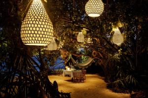 a room with trees and lights and a chair at Kudadoo Maldives Private Island &ndash; Luxury All inclusive in Lhaviyani Atoll