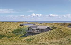 una casa en medio de un campo de hierba en Beautiful Home In Hvide Sande With 3 Bedrooms, Sauna And Wifi en Hvide Sande