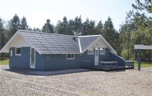 a blue tiny house with a pitched roof at Three-Bedroom Holiday Home In Oksbol in Oksbøl +11 photos
