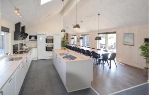 a kitchen with white cabinets and a dining room at Lovely Home In Grenaa With Sauna in Grenå
