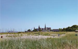 a large building in the distance with a field with grass at Awesome Studio In Helsingr With Kitchen in Helsingør