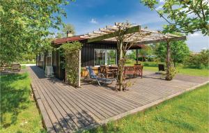 una terraza de madera con mesa y pérgola en Cozy Home In Holbk With House A Panoramic View, en Holbæk