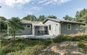 a small house with a deck in the yard at Holiday Home I Klitterne Nexø I in Spidsegård