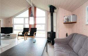 salon z kanapą i piecem opalanym drewnem w obiekcie Lovely Home In Lkken With Kitchen w mieście Løkken