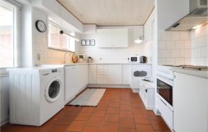 a kitchen with white cabinets and a washer and dryer at Three-Bedroom Holiday Home In Bredebro in Ballum