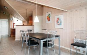 ein Esszimmer mit einem schwarzen Tisch und Stühlen in der Unterkunft Lovely Home In Lkken With Kitchen in Løkken