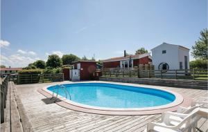 uma piscina num deque com duas cadeiras e uma casa em Skagenhuset Lejl, 3 em Allinge