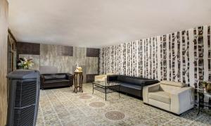a lobby with couches and chairs and a wall with patterns at Treebo Trend Srico in Hyderabad