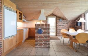 a kitchen with a brick wall and a table and chairs at Nice Home In Roslev With 3 Bedrooms, Sauna And Wifi in Sæby