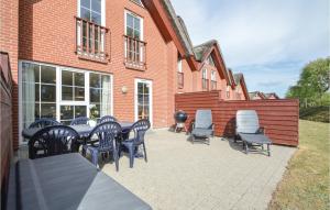 a patio with a table and chairs in front of a brick building at Awesome Home In Rm With 3 Bedrooms And Wifi in Bolilmark